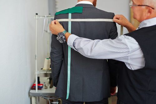 Tailor measuring back width of suit jacket