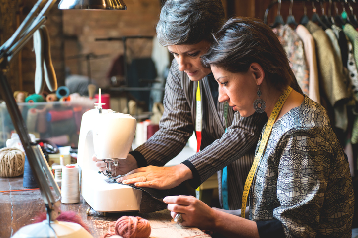 Seamstress Teaching her Assistant how to Use the Sewing Machine